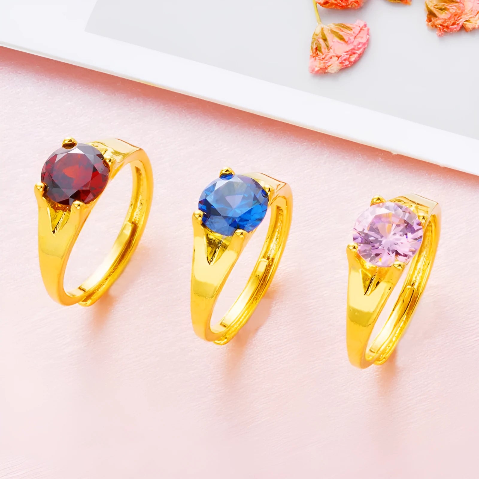 Adjustable copper ring with placer gold zircon accents shown in six colour options