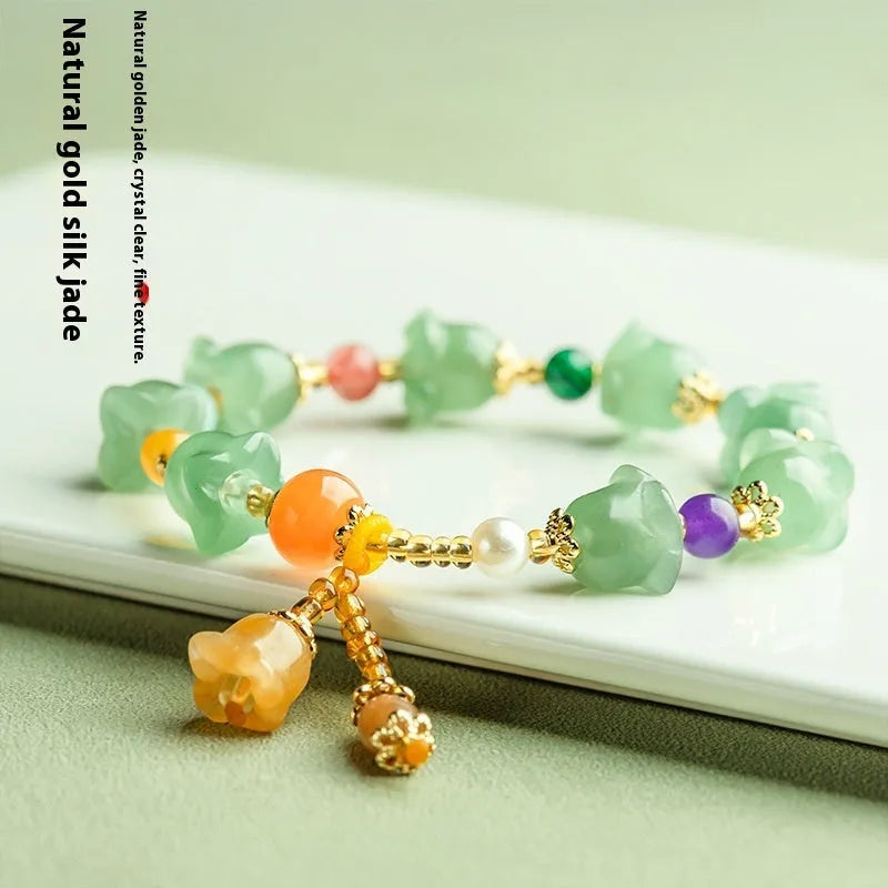 Natural Xinjiang Jinsi Jade aventurine orchid bracelet with carved orchid beads on a wrist.