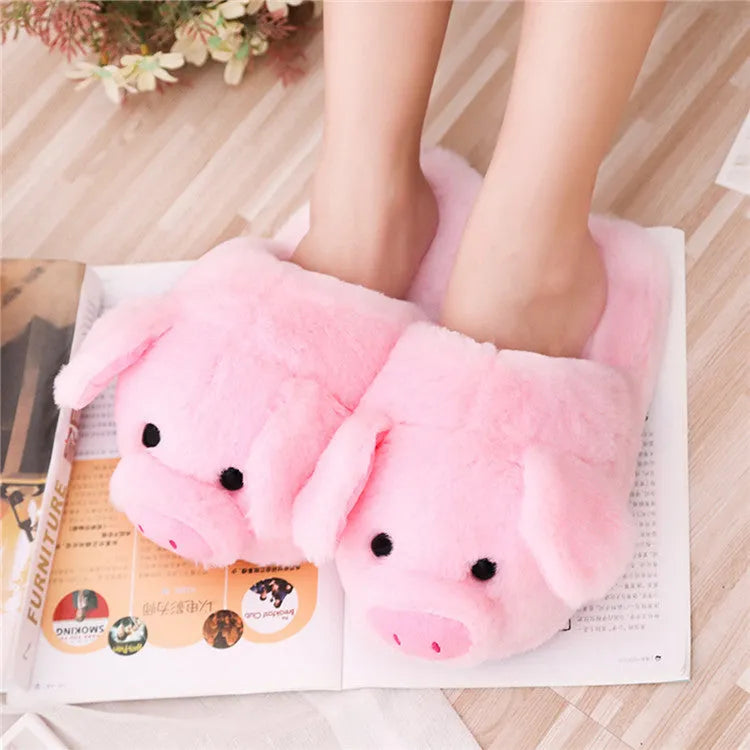 Pink pig-shaped plush floor slippers with a soft, textured surface and cushioned sole.