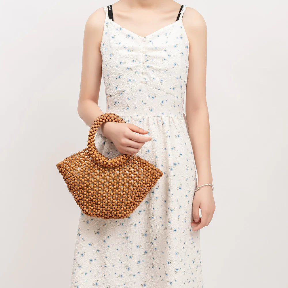 Hand-woven maple beach handbag with wooden beads in dumpling shape, shown in milky white colour