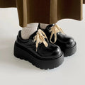 Matte black women's retro lace-up shoes with a thick sole and a muffin heel.