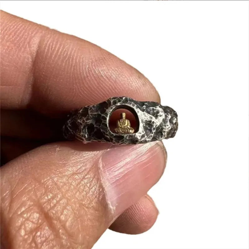 Close-up of a hand-forged copper ring with a textured Grotto Buddha and rock pattern.