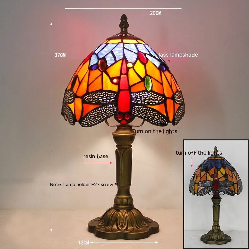 Stone Tiffany dragonfly table lamp in European retro style on a wooden table.