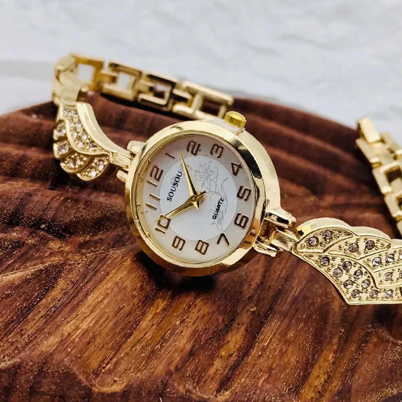 Stainless steel women's wristwatch with a round dial and vachette clasp, showing a gold-coloured surface.