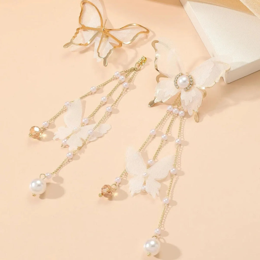 White butterfly-shaped earrings with dangling tassel, lace patterning, pearls, and clear rhinestones.