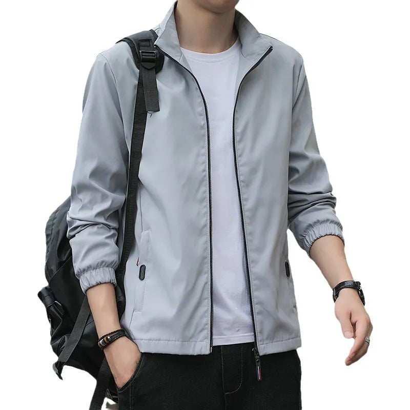 Man wearing a loose-fit grey Korean-style lapel casual jacket with zipper pockets.
