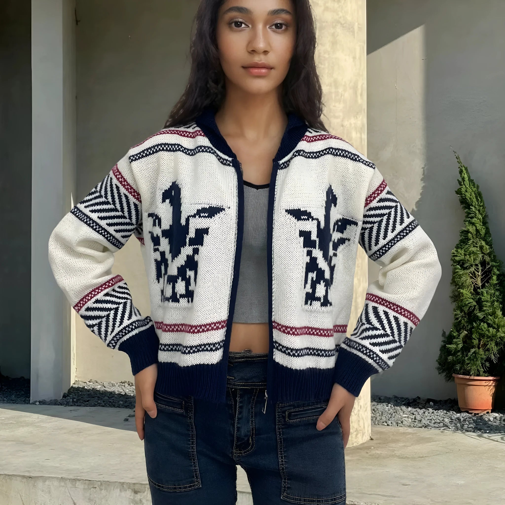 White women's cardigan with front zipper, lapel collar, and contrasting stripe jacquard pattern.