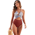 Women's black one-piece swimsuit with a printed red, yellow, and green patchwork leaf design.