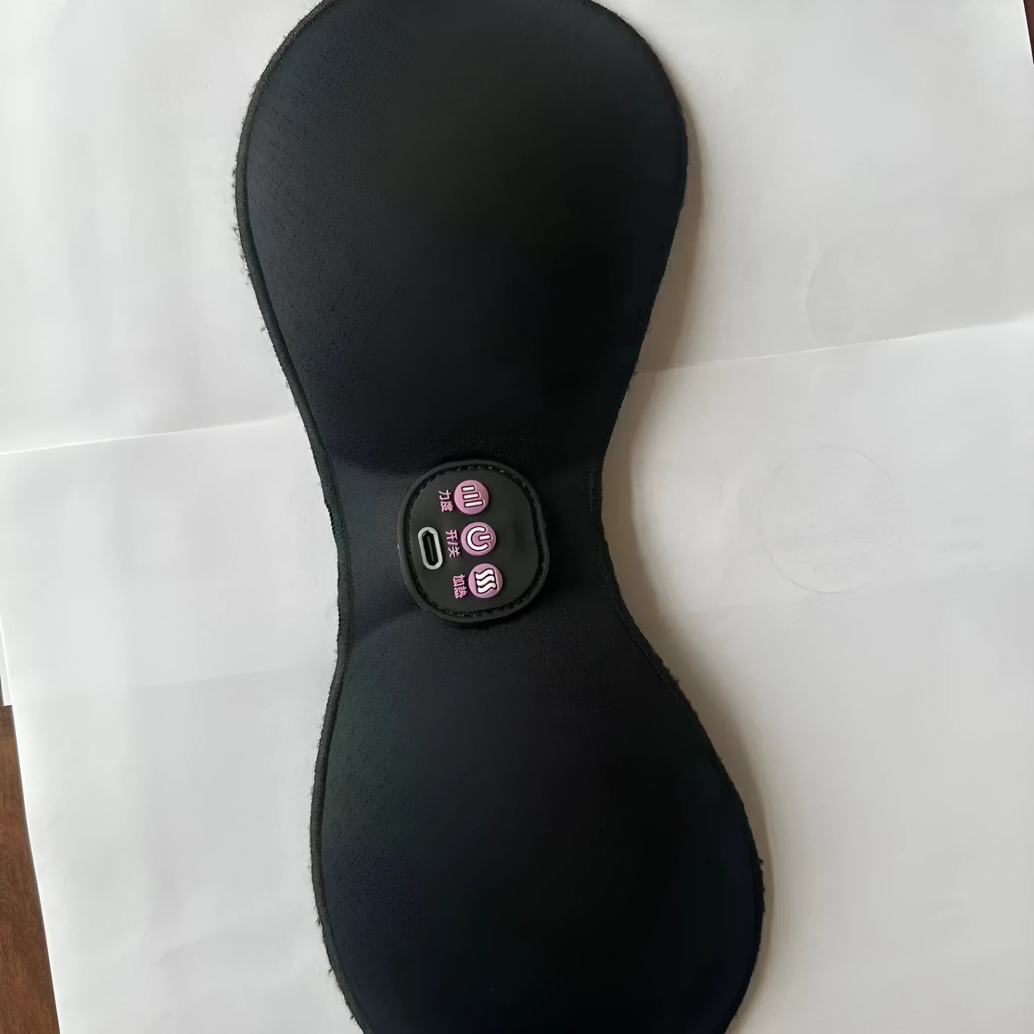 Black adhesive electric chest massage pads with three-key English control unit for hands-free vibration massage.