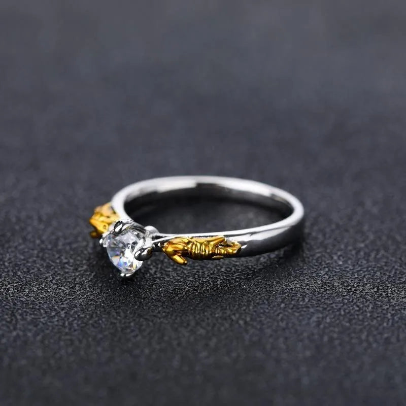 Black gold crystal crown ring on a finger, showing copper metal and decorative stones.