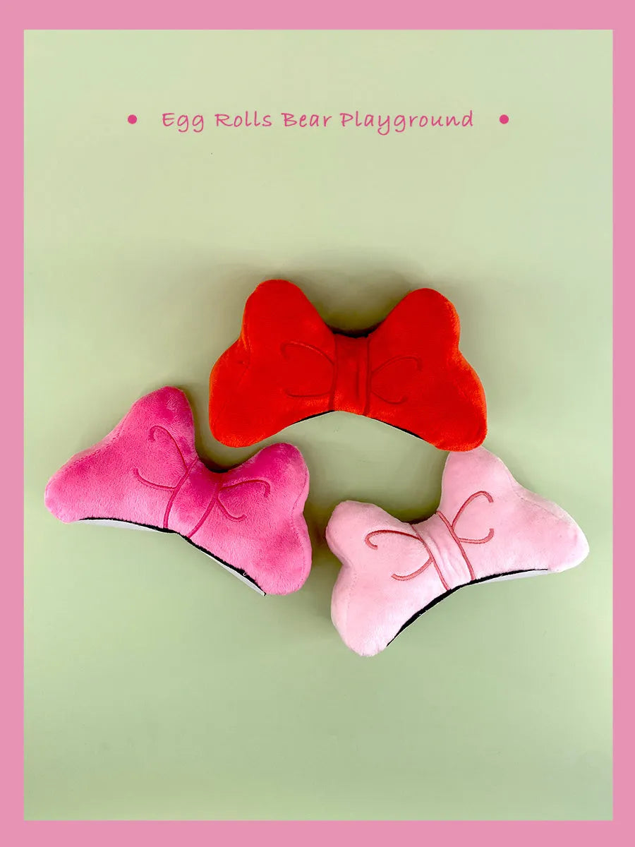 Soft plush red bow tie decoration for tying onto a motorcycle or ski helmet.