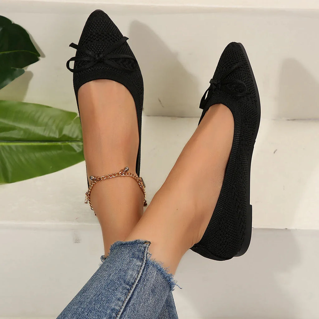 Women's knitted loafers with bow decoration in various colours showing flat rubber soles