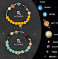 Two natural stone beaded bracelets with zodiac sign charms on a flat surface.