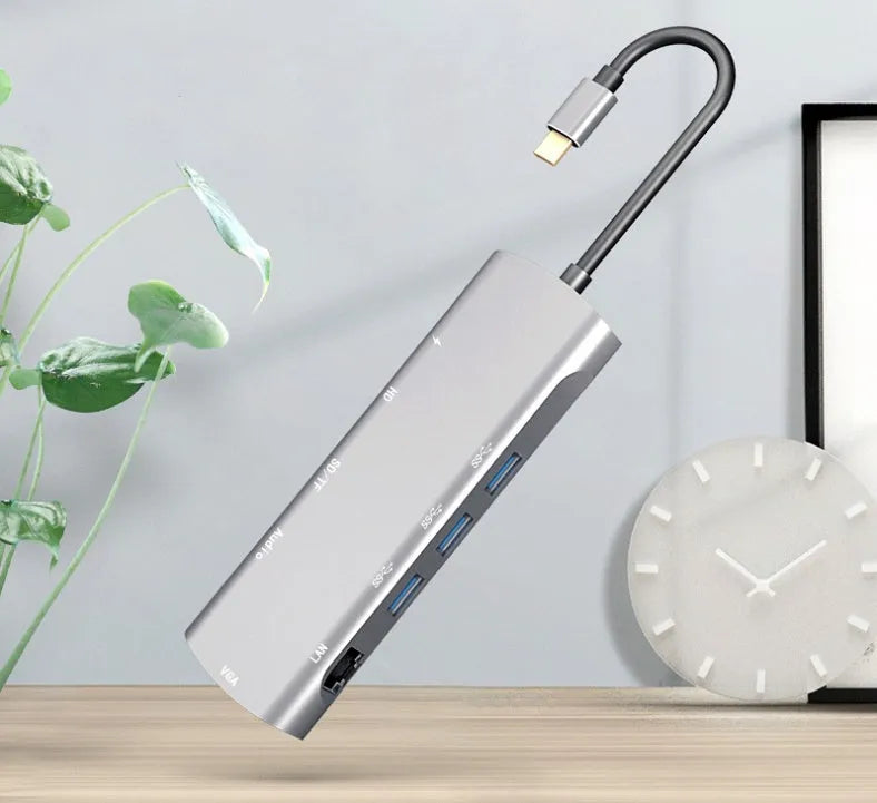 Grey aluminium USB-C docking station with HDMI, VGA, USB 3.0, and PD charging ports.