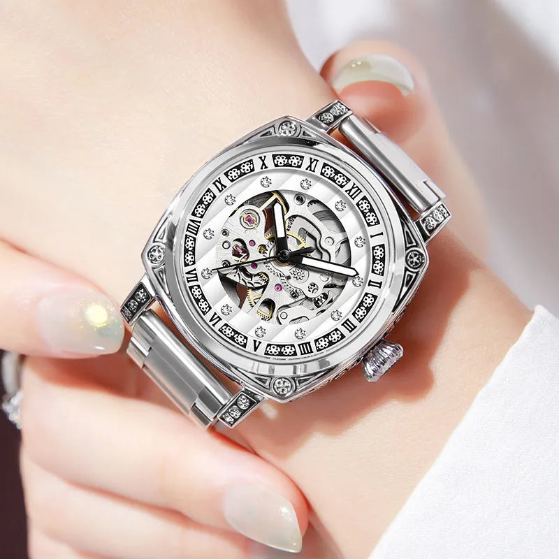 Mechanical watch with luminous hands on a leather strap, shown in black, red, steel, and white colour variants.