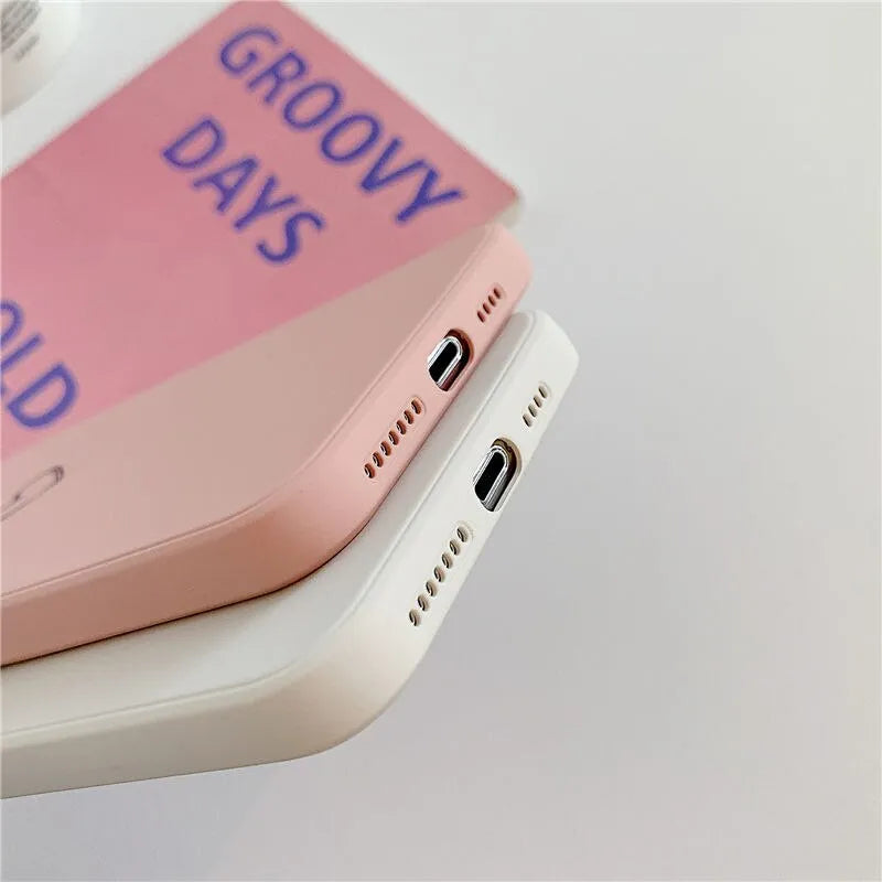 Silicone phone case for Apple iPhone in multiple solid colour options including black, pink, and purple