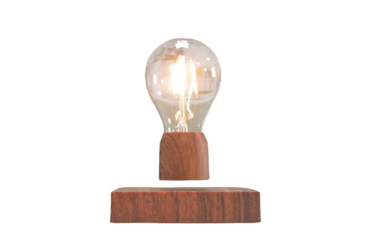 Magnetic levitating light bulb floating above an imitation wood base on a desk.