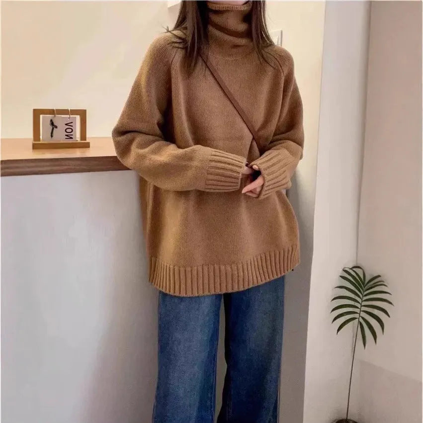 Women's loose grey turtleneck sweater with a thick 3D patterned texture and curling collar.