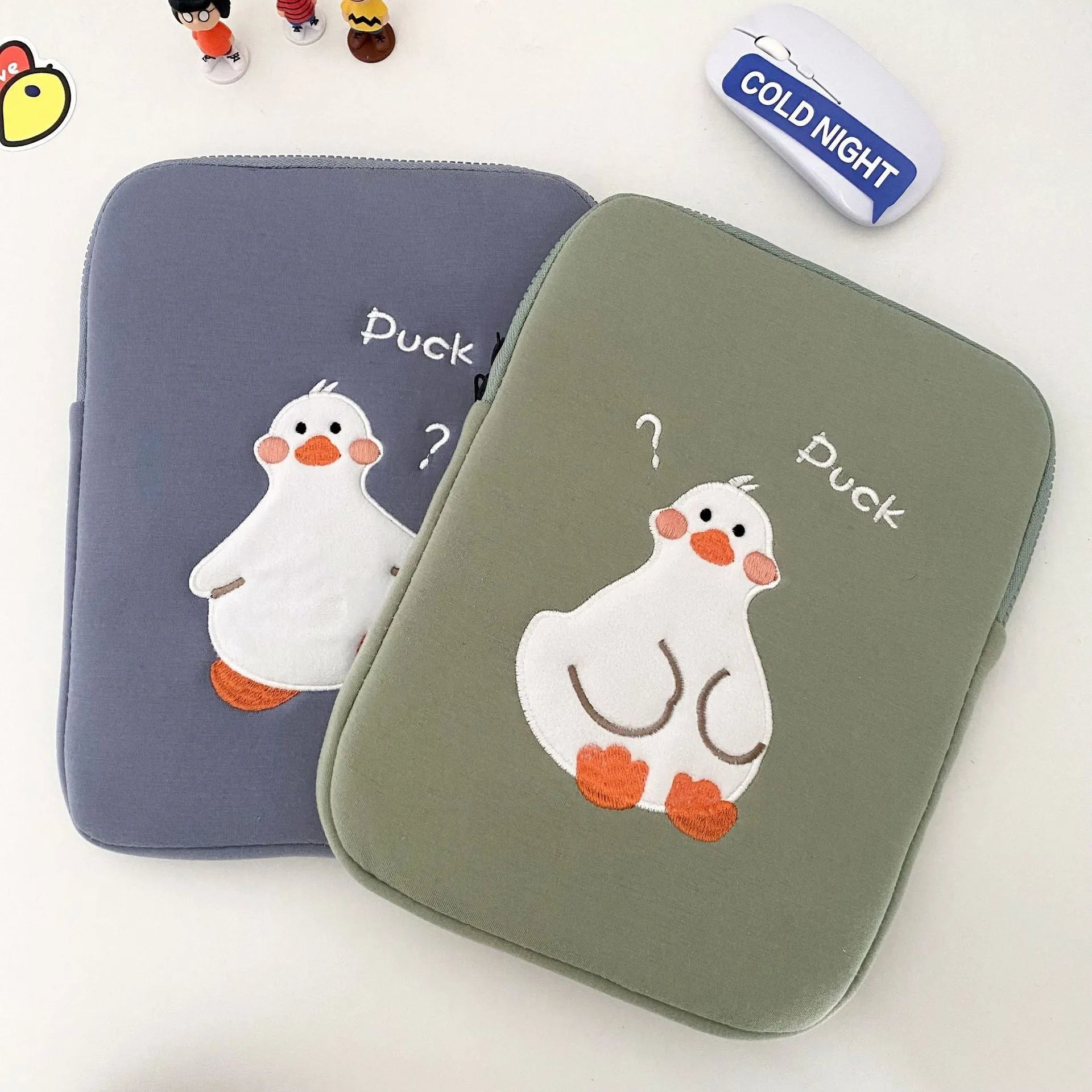 Blue cotton tablet case with embroidered cartoon duck design and a zip closure.