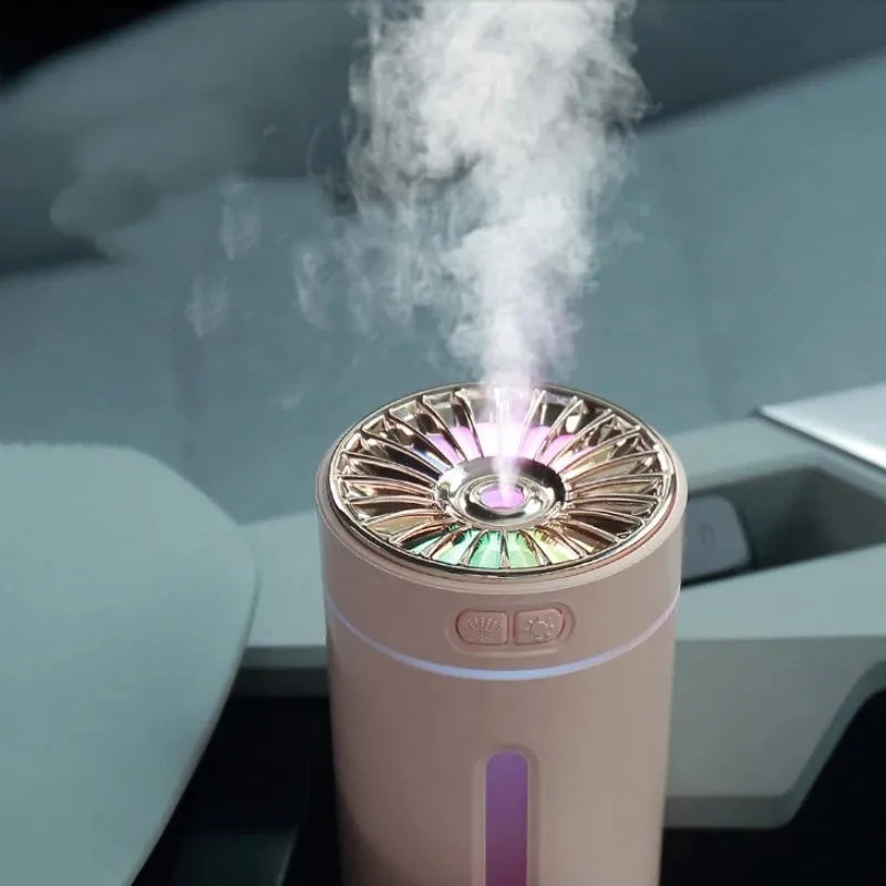 Black portable ultrasonic humidifier with colourful LED lights on a car cup holder.