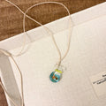Women's world style necklace with coloured glaze joker pendant on a cotton linen clavicle chain.
