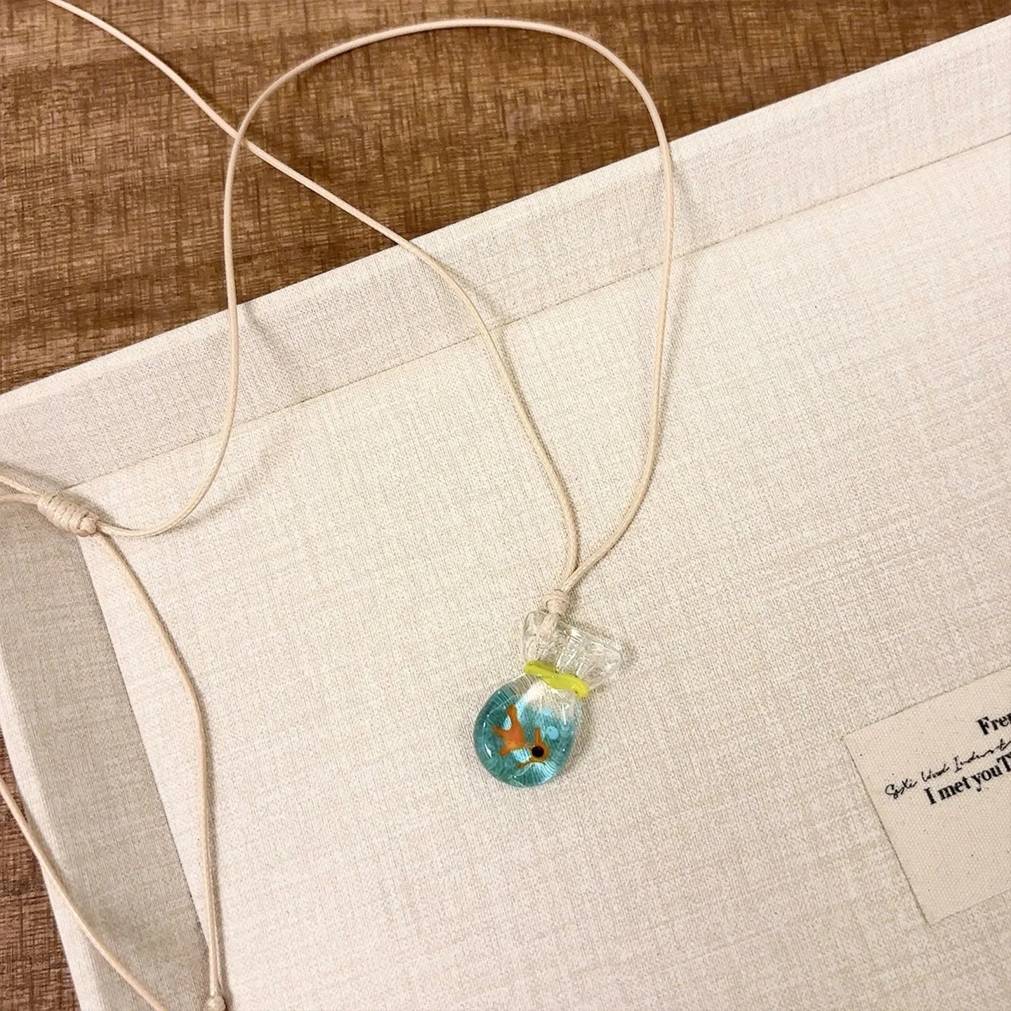 Women's world style necklace with coloured glaze joker pendant on a cotton linen clavicle chain.