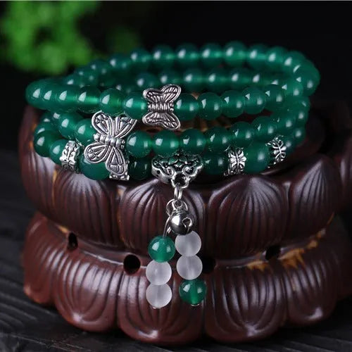Close-up of a women's multi-strand bracelet with green agate beads on a wrist.
