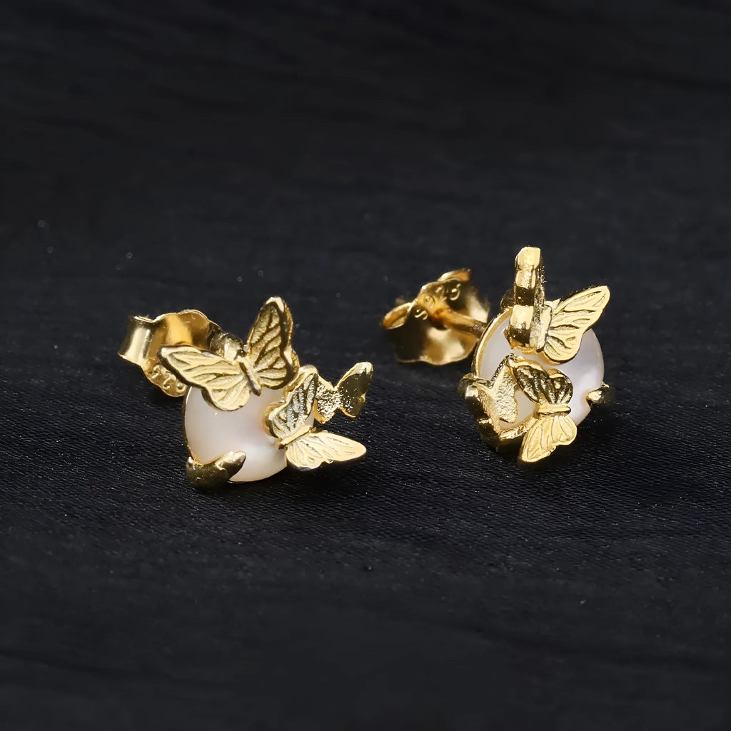 A pair of silver butterfly ear studs with animal zodiac design in gold or white gold colour.