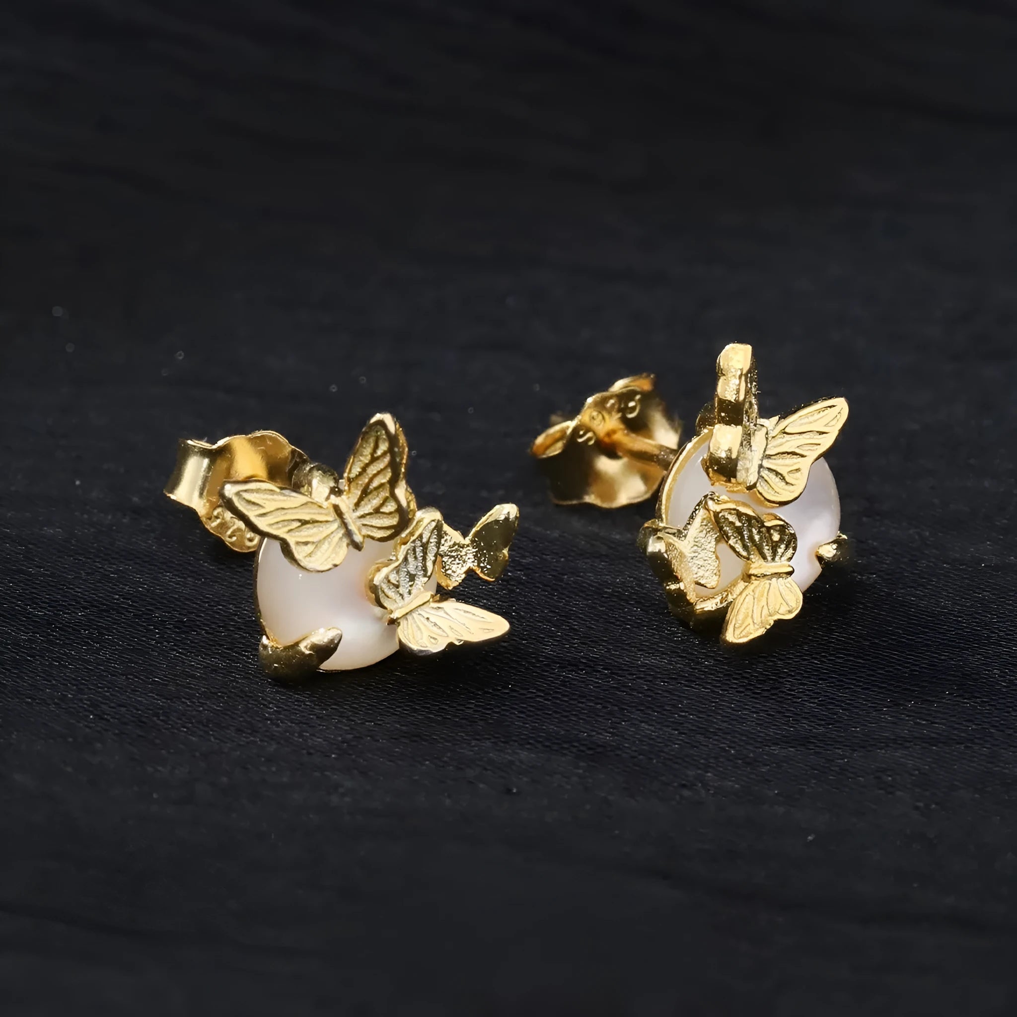 A pair of silver butterfly ear studs with animal zodiac design in gold or white gold colour.
