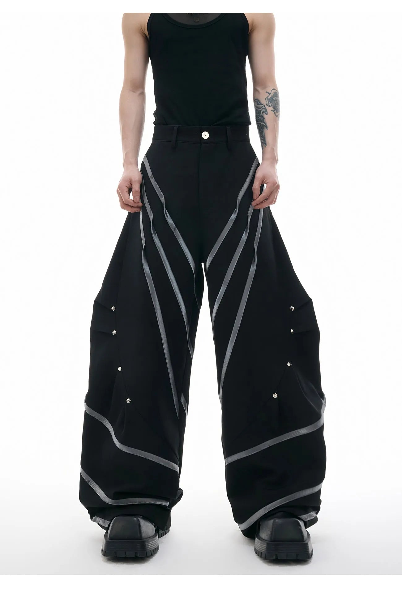 Men's black trousers with three-dimensional cut, metal striped rivets, and pleated detailing