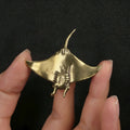 Brass devil fish ornament figurine on a surface, showing metallic colour and intricate devil fish design