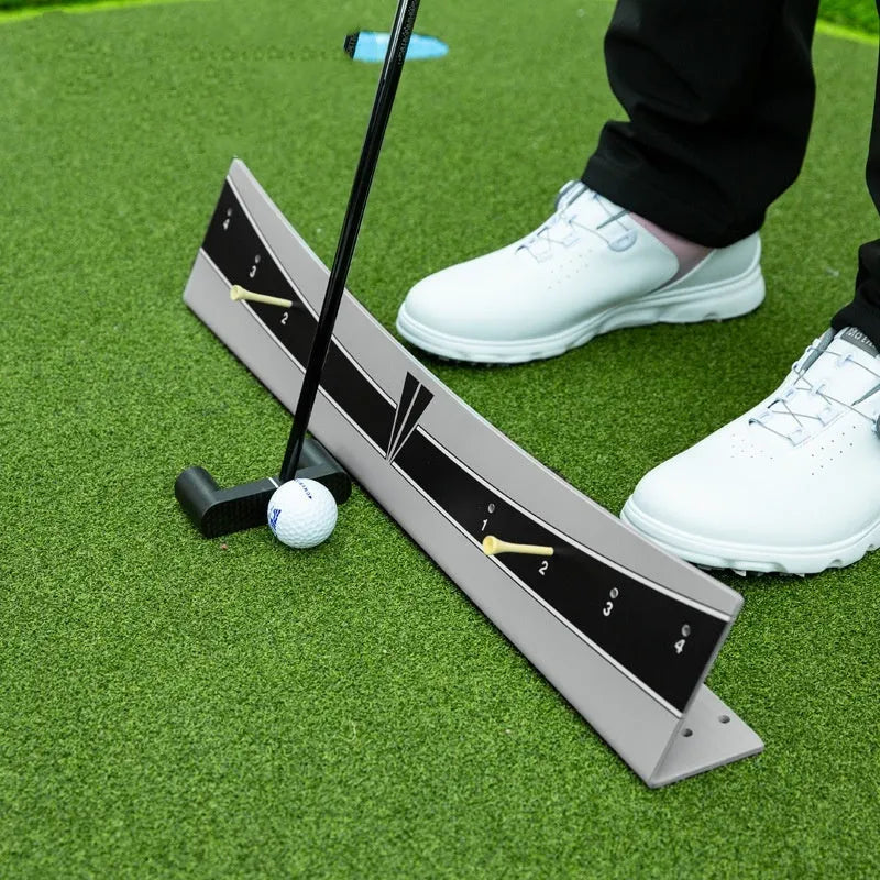 Close-up of an adjustable PVC golf putter trajectory balance simulator on a flat surface.