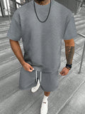 Men's blue short sleeve shorts leisure suit on a hanger, showing the top and pants.