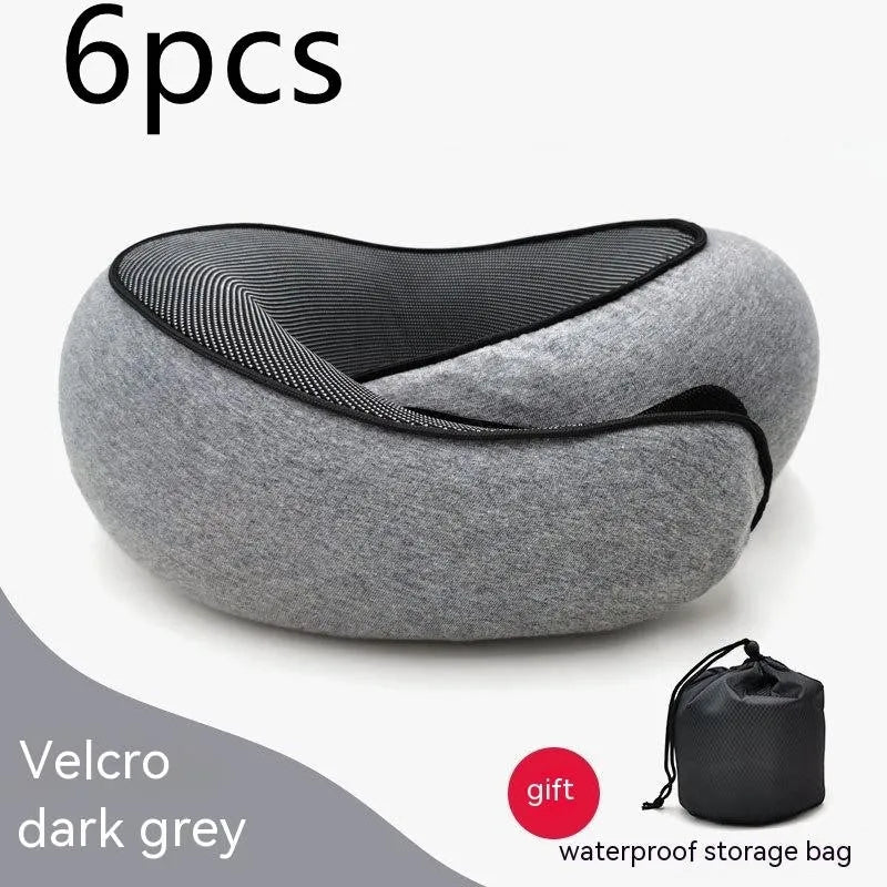 U-shaped navy blue travel neck pillow with memory foam, shown rolled up next to its carry bag.