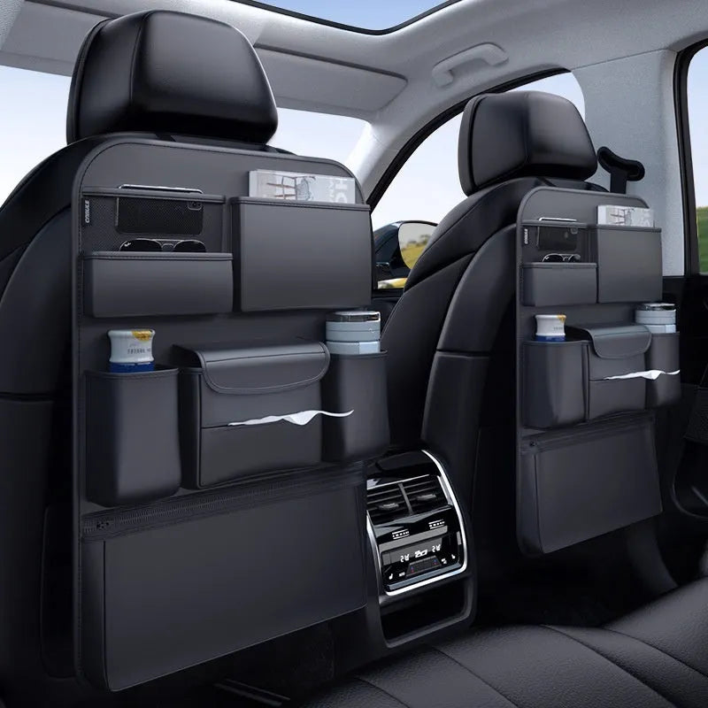 Black leather car seat back storage hanging bag with handle shown behind vehicle seat