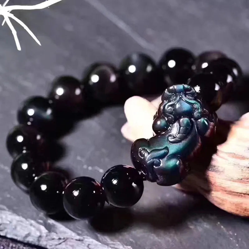 Natural eye obsidian crystal bracelet with ice colour tones and silver clasp on a wrist.