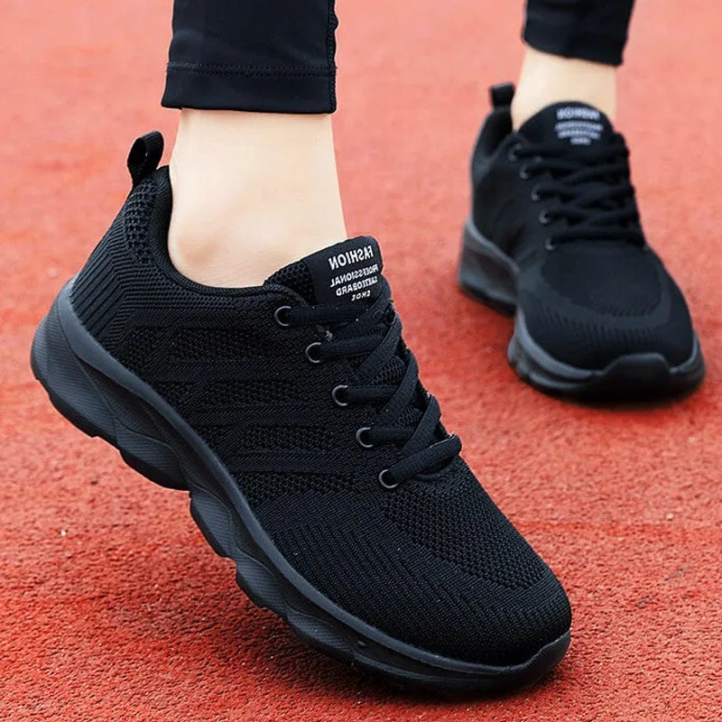 Women's white mesh lace-up leisure shoe with round toe and low heel on a plain background.