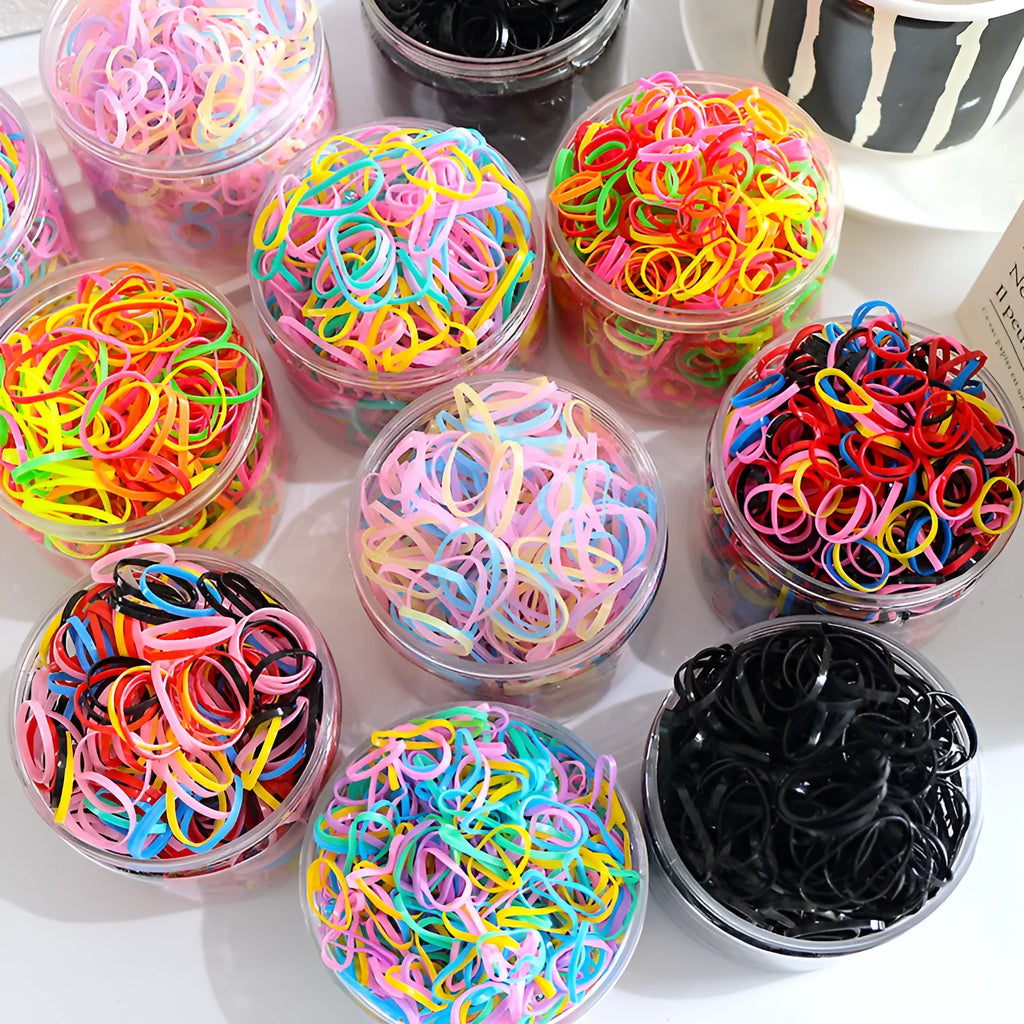 Pack of multicoloured thin TPU baby hair ties for toddlers in a reusable clear storage container.