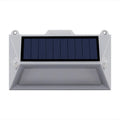 Solar-powered outdoor step light with motion sensor in abstract design on a brick step.