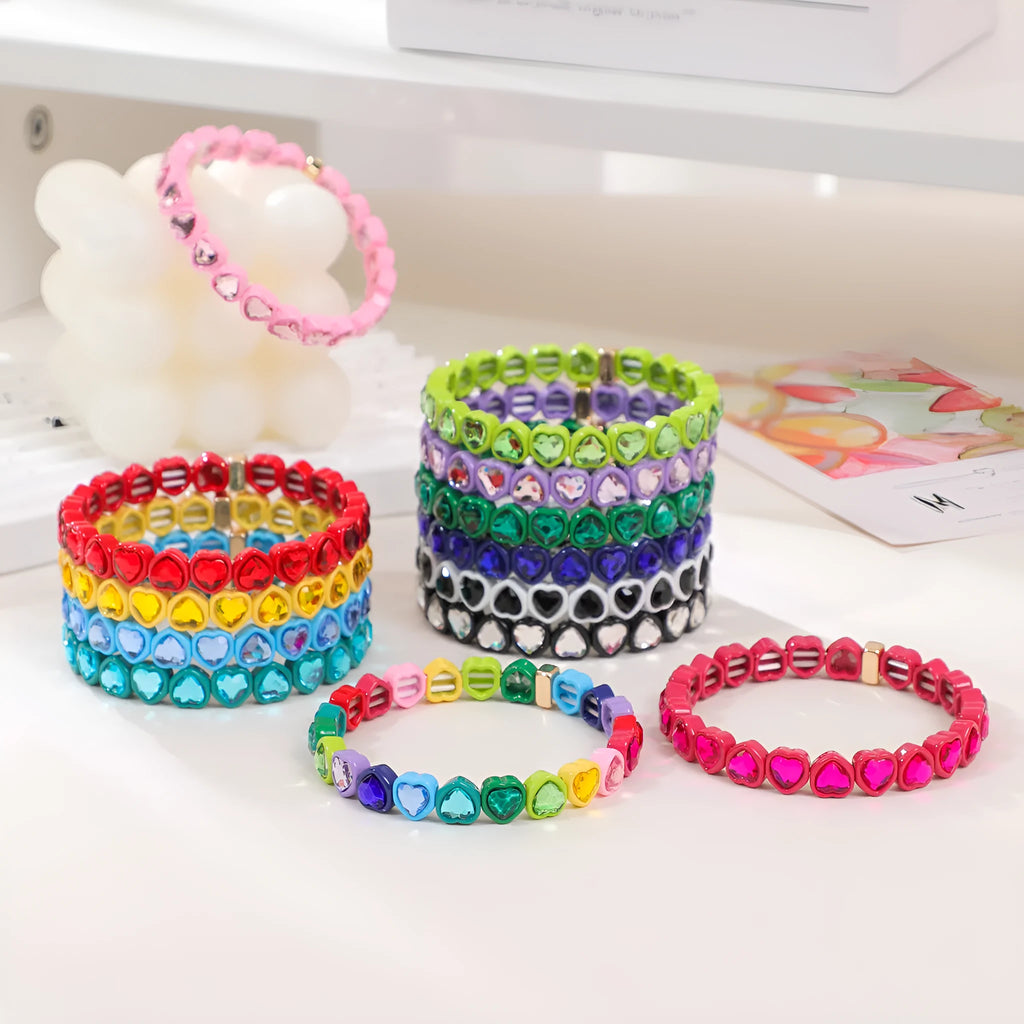 Colourful enamel finish alloy heart charm on a black stretch bracelet band.