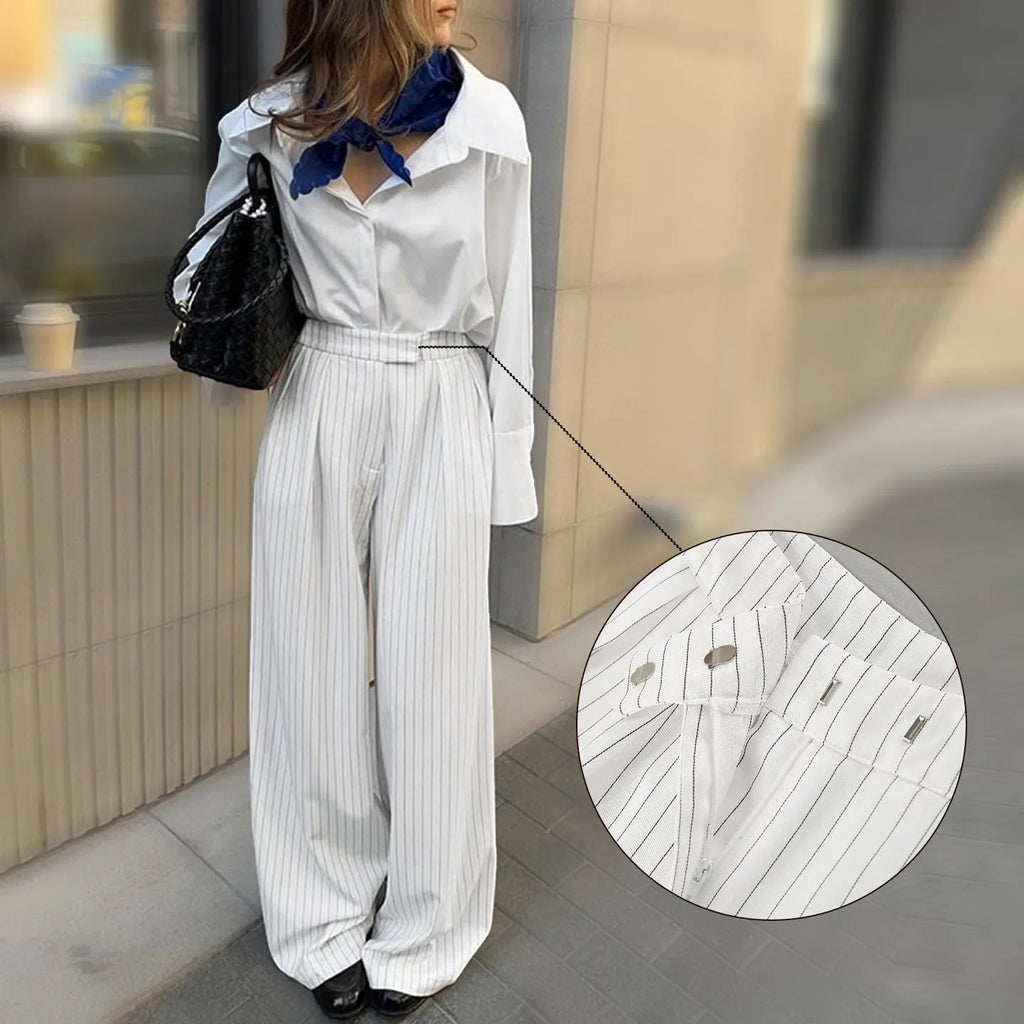 White wide-leg trousers with vertical stripes, featuring a loose casual fit and a front zipper fastening.