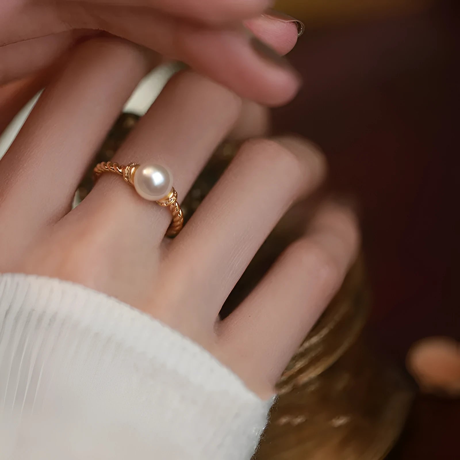 Adjustable copper ring with antique twist design and inlaid pearl in gold finish.