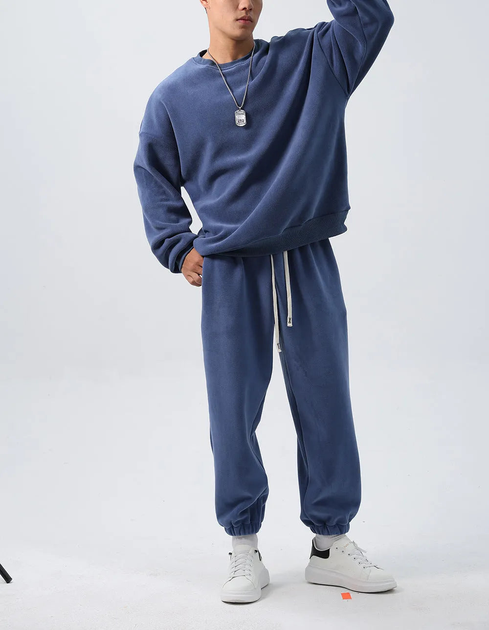 Man wearing a black polar fleece sports suit with a crew neck coat and loose trousers.