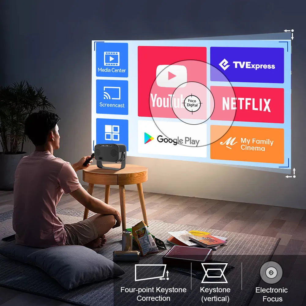 Black compact HD smart portable projector with remote control on a table.