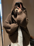 A woman wearing a brown retro-style hooded cardigan with thick knit fabric.