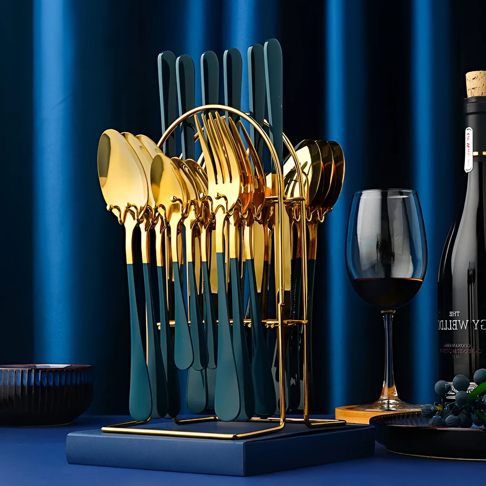 Gold 24-piece stainless steel cutlery set with knives, forks, spoons, and a storage rack.