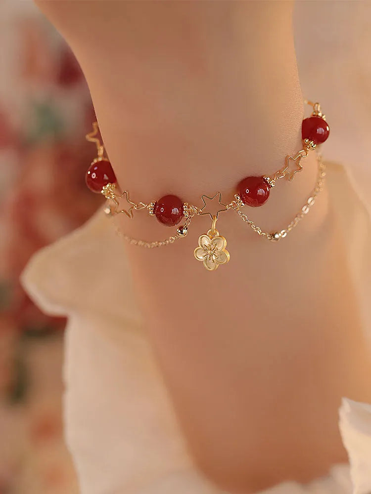 Red agate double layer bracelet with floral and peach blossom detailing on woman's wrist