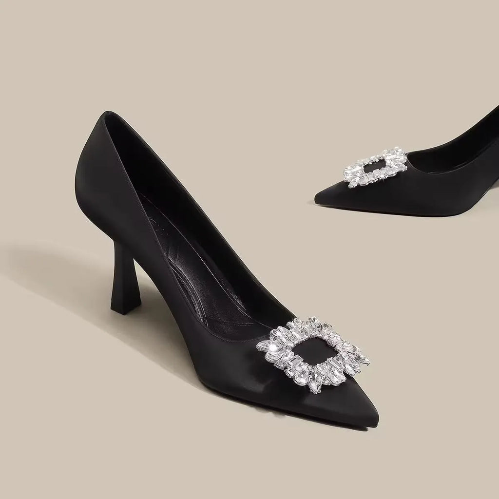 Women's creamy-white pointed toe stiletto pumps with a mid-height heel on a plain background.