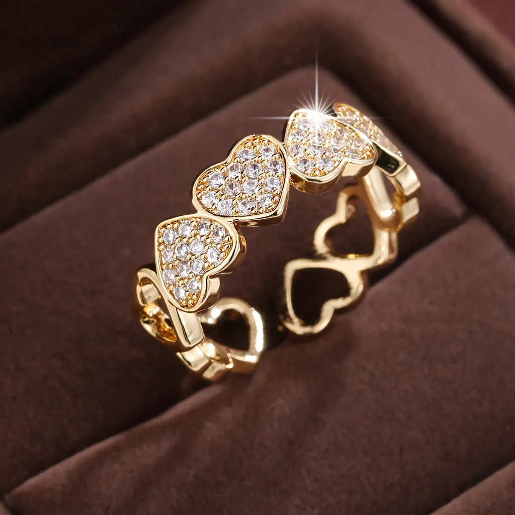 Gold and silver adjustable heart-shaped couples ring on a small finger.