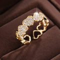 Gold and silver adjustable heart-shaped couples ring on a small finger.